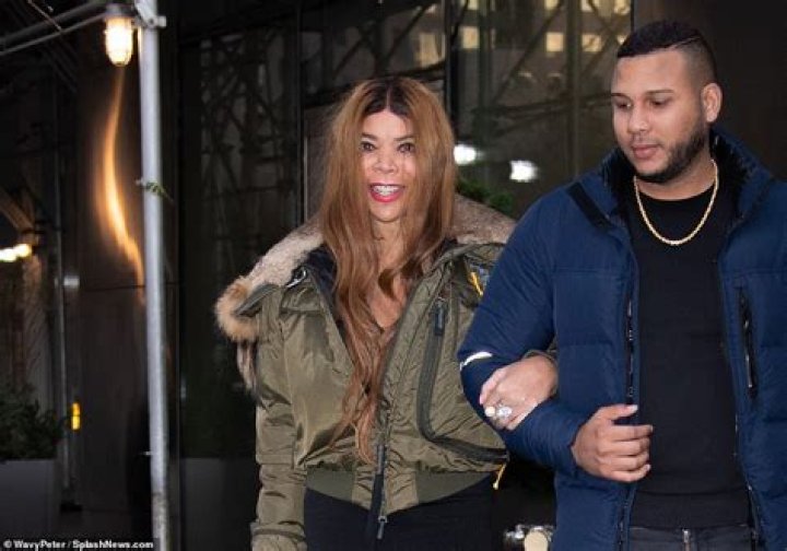 Wendy Williams, 58, takes the arm of a young male companion as she